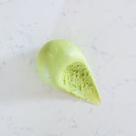 A light green ball of soft play dough placed on a white marble surface.