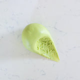 A light green ball of soft play dough placed on a white marble surface.